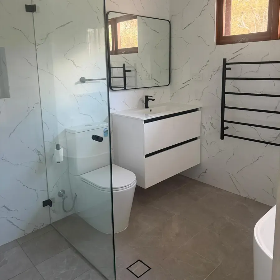 Walk-in shower, toilet, wall-hung vanity and linear floor drain in the renovated Katoomba bathroom by Quick Mick’s Plumbing